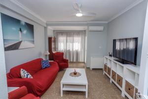 uma sala de estar com um sofá vermelho e uma televisão em Apartamento Playa Santa María del Mar em Cádiz