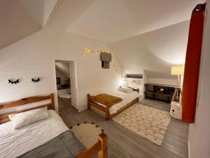 a attic room with two beds and a piano at Le Clos de la Michaudiere in Cellettes