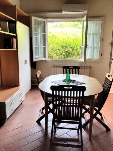 een keuken met een tafel en stoelen en een raam bij Agriturismo Piccolo Paradiso in Riparbella