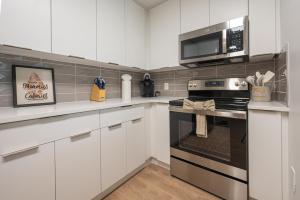 a kitchen with white cabinets and a microwave and an oven at Live Beautifully Uptown in Charlotte