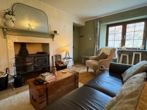 a living room with a blue couch and a fireplace at Rosemount Bothy - Highland Cottage in Garve