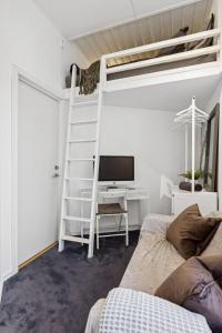 オスロにあるCozy room in central Oslo Grunerløkkaのベッドルーム1室(二段ベッド1組、デスク、テレビ付)が備わります。