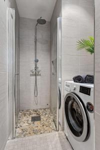 uma máquina de lavar roupa na casa de banho com um chuveiro em Cozy room in central Oslo Grunerløkka em Oslo