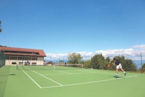 a man playing tennis on a tennis court at Lugrin proche du Lac et Montagne in Lugrin