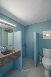Baño azul con lavabo y aseo en Villa Ganema 2, en Ganema