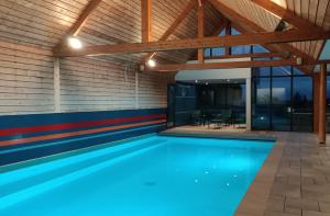 Una piscina cubierta con agua azul en una casa. en Les Gîtes du Pêcheur, en Erquy