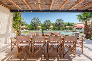 eine Terrasse mit einem Tisch, Stühlen und einem Pool in der Unterkunft Villa Toscane in Saint-Tropez