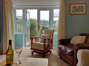 uma sala de estar com uma cadeira e um copo de vinho em Garreg Wen - White Stone, family holiday home em Barmouth