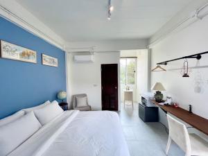 a bedroom with a white bed and a blue wall at Self check-in apartment by Baiput Hometel in Phra Nakhon Si Ayutthaya