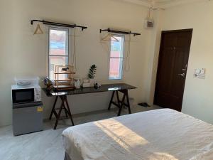a bedroom with a desk with a bed and a microwave at Self check-in apartment by Baiput Hometel in Phra Nakhon Si Ayutthaya