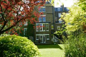 a large brick house with red trees in front of it at Garden flat in a quiet Camden spot in London