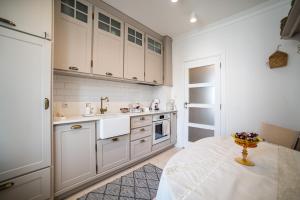 a kitchen with white cabinets and a table in it at Apartment Antique Theatre 3 - RETRO in Stara Zagora