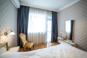 a bedroom with a bed and a chair and a window at Apartment Antique Theatre 3 - RETRO in Stara Zagora