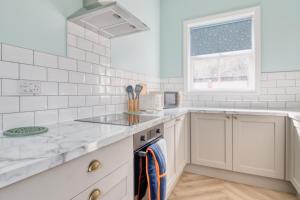 uma cozinha com electrodomésticos brancos e uma janela em The Yorkshire Hosts - Enholmes Coach House em Hull