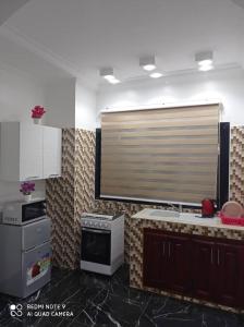 una cocina con fregadero y una ventana. en HOTEL APPART B4U - BE FOR YOU, en Yaoundé