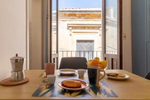 een tafel met ontbijtproducten en uitzicht op de eiffeltoren bij La Casa dei Mori - Ortigia Central Apartment in Siracusa