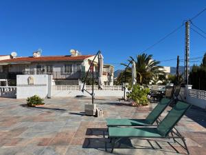 una silla verde sentada en un patio frente a una casa en Apartamento en el Albir - Inmodream Calpe, en Albir