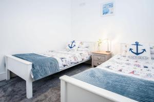 a bedroom with two beds and a nautical themed bedroom at Pencw Garden View - 3 Bed Apartment - Saundersfoot in Saundersfoot
