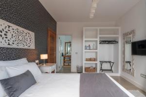 a bedroom with a white bed and a wall at Villa Shepherd Lajares - LUXURY VILLA FUERTEVENTURA in Lajares