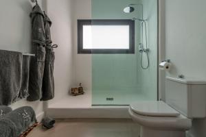 a bathroom with a shower and a toilet and a window at Villa Shepherd Lajares - LUXURY VILLA FUERTEVENTURA in Lajares