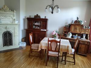 ein Esszimmer mit einem Tisch, Stühlen und einem Kamin in der Unterkunft historisches Winzerhaus mit Moselblick in Lieser