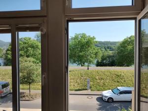 ein Fenster mit Blick auf ein Auto auf einem Parkplatz in der Unterkunft historisches Winzerhaus mit Moselblick in Lieser
