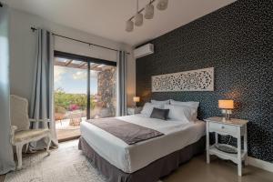 1 dormitorio con cama grande y ventana grande en Villa Shepherd Lajares - LUXURY VILLA FUERTEVENTURA, en Lajares