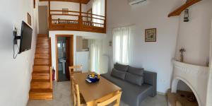 a living room with a couch and a table at Pelagos Rooms on Gyrismata beach in Skiros