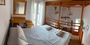 a bedroom with a bed and a mirror at Pelagos Rooms on Gyrismata beach in Skiros