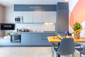 cocina con armarios azules y mesa de madera en La Casa Nelle Aie - App. Nebbiolo -Box Auto & WiFi, en La Morra