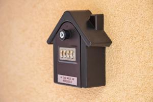 una toma de corriente en forma de casa negra en una pared en La Casa Nelle Aie - App. Nebbiolo -Box Auto & WiFi, en La Morra