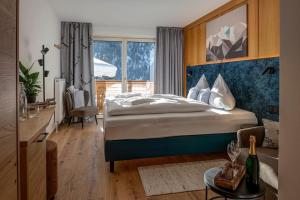 a bedroom with a bed and a large window at Hotel FoKus in Sankt Jakob in Defereggen