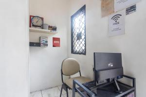 escritorio con ordenador y silla en una habitación en OYO 93720' 3D Residence Near Univ Tarumanegara en Yakarta