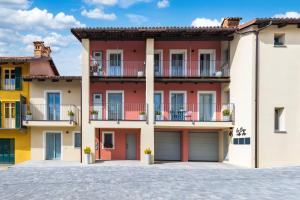 un gran edificio de apartamentos con balcones y garajes en La Casa Nelle Aie - Appartamento Dolcetto - Private Parking - Free Wifi & AC, en La Morra