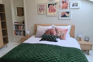 een vrouw op een bed met een groene deken bij In the heart of the village - Charming & Authentic in Monpazier