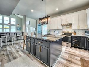 a kitchen with white cabinets and black counter tops at Beachfront Million Dollar Views 2 King Beds Big Tv in Galveston