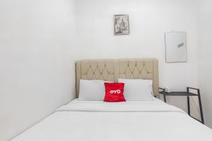 almohada roja en la parte superior de una cama en OYO 93720' 3D Residence Near Univ Tarumanegara en Yakarta