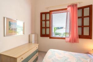 a bedroom with a bed and a desk and a window at Casa Vacanze Maria in San Vito lo Capo