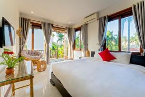 1 dormitorio con 1 cama blanca grande y ventanas grandes en New Sunshine Homestay, en Hoi An