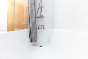 a bathroom with a tub and a shower at GuestReady - Uma joia escondida em Brighton in Brighton & Hove