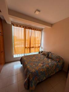 sypialnia z łóżkiem i dużym oknem w obiekcie Apartamentos El Viñedo 8 w mieście General Alvear