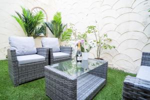 a patio with wicker chairs and a glass table at GuestReady - Refúgio à beira-mar com terraço in Brighton & Hove