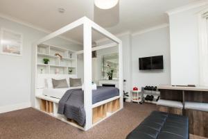 a bedroom with a white bed with a mirror at GuestReady - Classy Studio in Brighton in Brighton & Hove