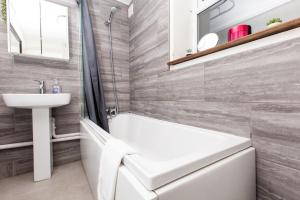 a bathroom with a sink and a tub and a toilet at GuestReady - Classy Studio in Brighton in Brighton & Hove