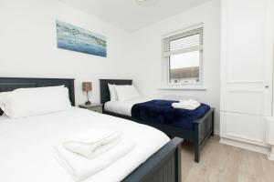 a bedroom with two beds and a window at Stylish Seaside Stay – Brighton Marina Views in Brighton & Hove