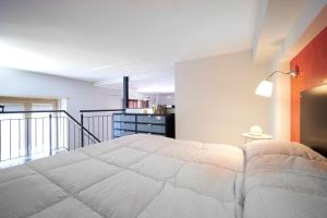 a bedroom with a large bed and a balcony at Loft Santa Giulia in Turin