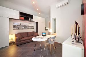 a living room with a couch and a table with a laptop at Loft Santa Giulia in Turin