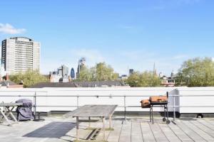 a picnic table and chairs on top of a building at Spacious luxury central London 1-bed apartment in London