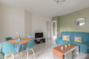 ein Wohnzimmer mit einem blauen Sofa und einem Tisch in der Unterkunft Fonctionnel et Calme avec parking gratuit in Villeurbanne