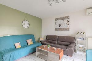 ein Wohnzimmer mit einem Sofa und einem Tisch in der Unterkunft Fonctionnel et Calme avec parking gratuit in Villeurbanne